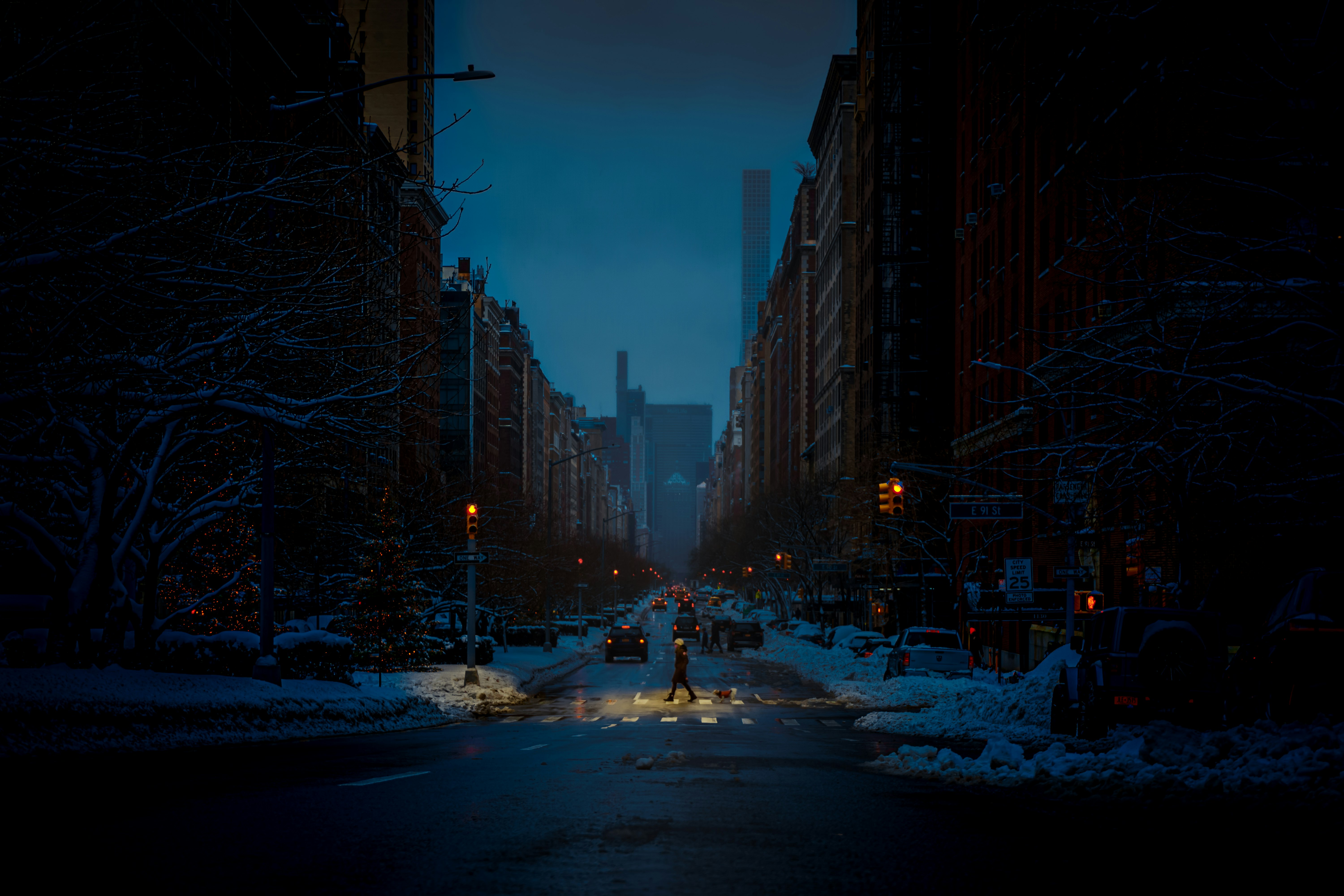 cars on road between high rise buildings during night time